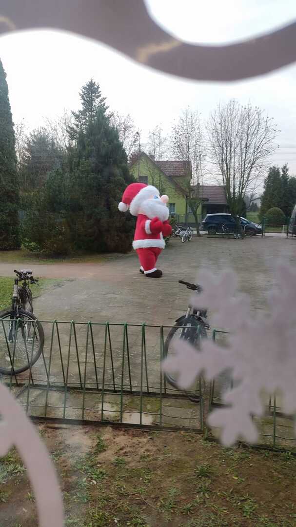 Św. Mikołaj spacerujący za oknami przedszkola. Na zewnątrz.
