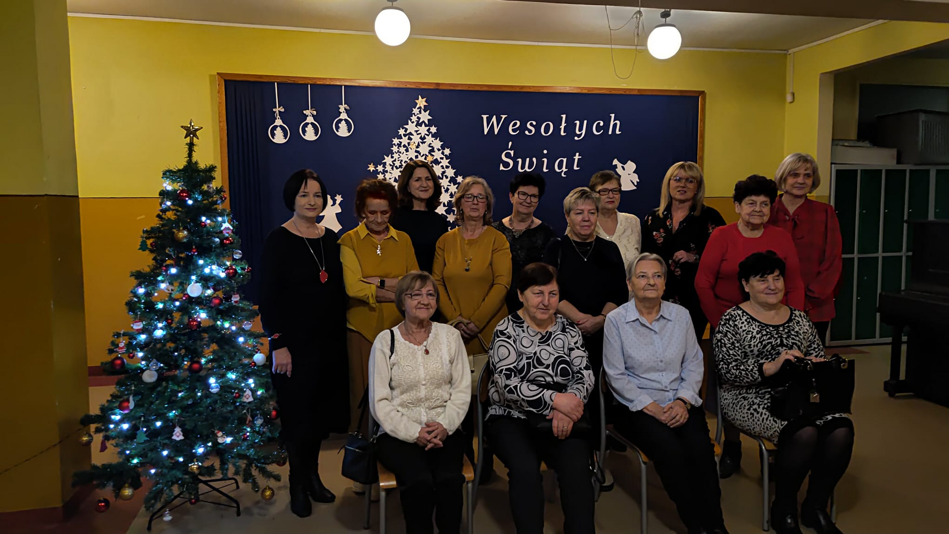 Grupa osób pozująca do zdjęcia. Wewnątrz.
