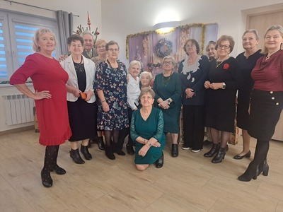 Grupa seniorów pozująca do zdjęcia. Wewnątrz.