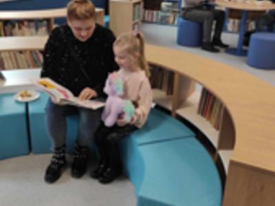 Grupa osób w sali bibliotecznej. Wewnątrz.