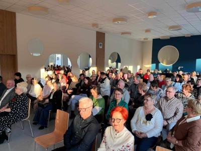 Zdjęcie wykonane wewnątrz pomieszczenia. Na zdjęciu widoczna duża grupa osób