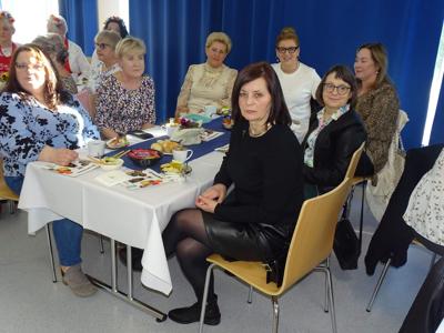 Grupa kobiet siedząca przy stole. Wewnątrz.