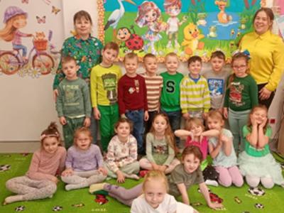 Grupa dzieci i 2 panie pozujący do zdjęcia. Wewnątrz.