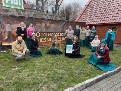 Chórzyści pozujący do zdjęcia. Na zewnątrz.