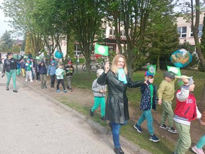 Grupa dzieci i opiekunki podczas marszu. Na zewnątrz.