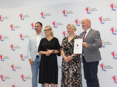 4 osoby pozują do zdjęcia. Wewnątrz.