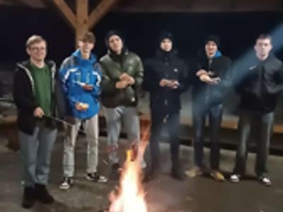 zawodnicy drużyny FC Drzycim, stoją przy ognisku i pieką kiełaski – na dworze