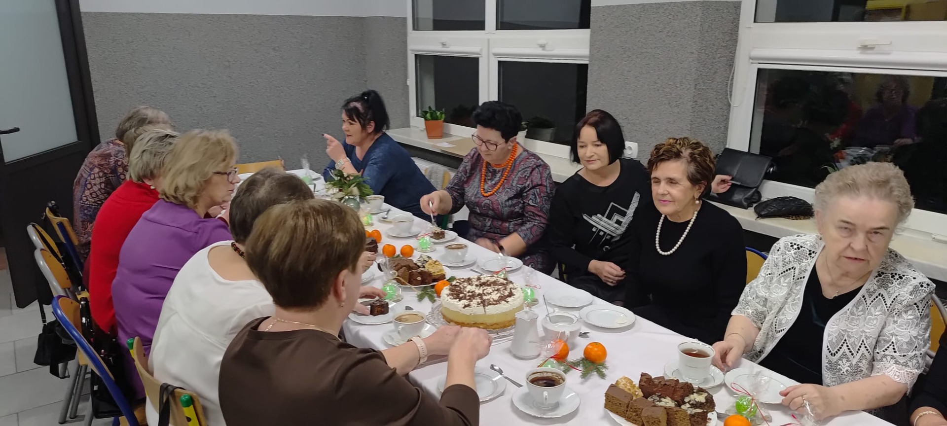 Grupa kobiet siedząca przy stole. Wewnątrz