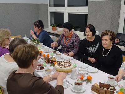 Grupa kobiet siedząca przy stole. Wewnątrz