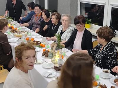 Grupa kobiet siedząca przy stole. Wewnątrz