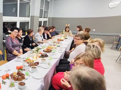 Grupa kobiet siedząca przy stole. Wewnątrz