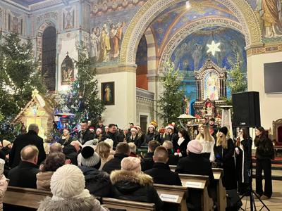 Nawa kościoła z zebranymi ludźmi. Wewnątrz