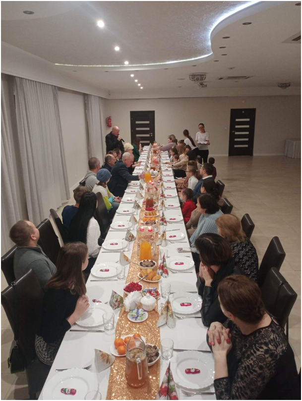 grupa osób siedzących przy stole – wewnątrz budynku