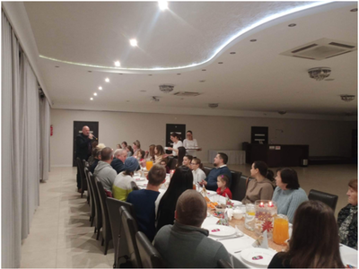 grupa osób siedzących przy stole – wewnątrz budynku