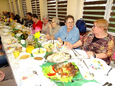 Trzy osoby przy zastawionym stole. Wewnątrz.