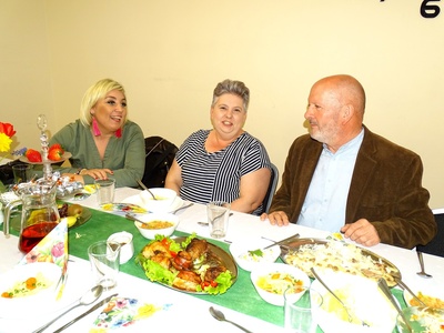 Seniorzy przy zastawionym stole. Wewnątrz.