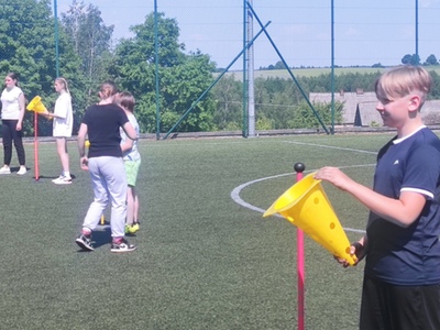 Grupa dzieci podczas konkurencji sportowych. Na zewnątrz.