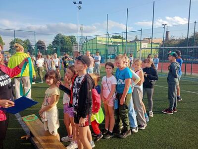 Grupa dzieci na boisku Orlik podczas zabawy. Na zewnątrz.