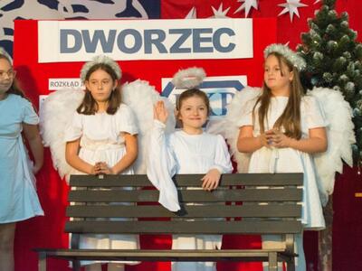 wewnątrz, na scenie dwaj główni bohaterowie w strojach osób bezdomnych siedzą na ławce.