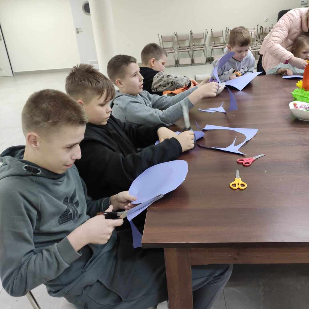 Na zdjęciu widoczna grupa dzieci w trakcie trwania zajęć plastycznych. Zdjęcie wykonane wewnątrz pomieszczenia.
