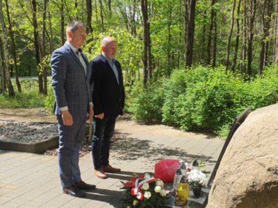 Mogiła zbiorowa żołnierzy Wojska Polskiego, las, kwiaty, znicze.