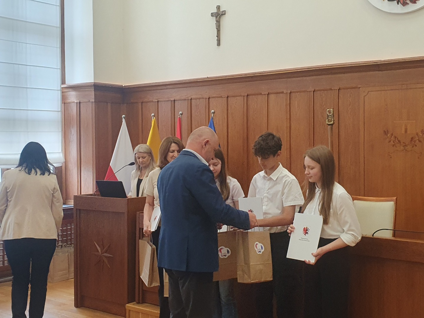 Marszałek wręcza podziękowania młodzieży. Wewnątrz.