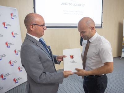 Złożenie podpisu przez Zastępcę Wójta na pamiątkowej tablicy. Wewnątrz.