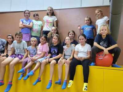 Grupa uczniów siedzi lub stoi w sali trampolin /wewnątrz/