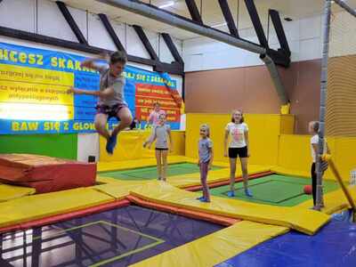 Grupa uczniów skacze na trampolinach /wewnątrz/