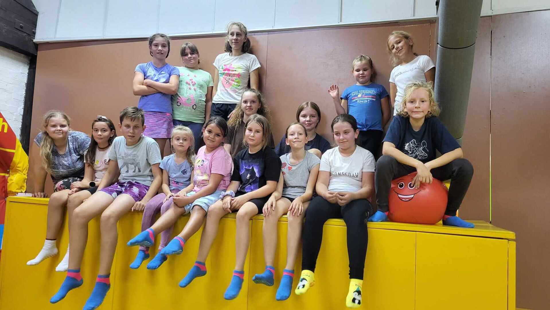 Grupa uczniów siedzi lub stoi w sali trampolin /wewnątrz/