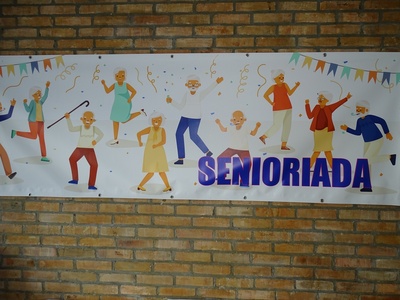 Plakat z napisem SENIORIADA. Wewnątrz.