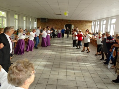 Grupa seniorów w trakcie tańca. Wewnątrz.