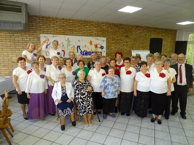 Grupa seniorów pozująca do zdjęcia. Wewnątrz.