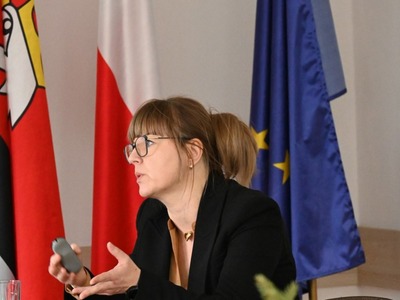 głos zabiera Dyrektor CUW w Kętrzynie, w tle flagi 