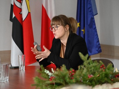 głos zabiera Dyrektor CUW w Kętrzynie, w tle flagi 