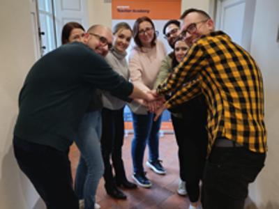 zdjęcie grupowe wszystkich uczestników kursu, ludzie stoją w okręgu, każdy jedną z dłoni ma ułożoną w środku okręgu