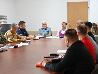 członkowie zespółów siedzą przy stole w sali konferencyjnej - trwają obrady