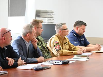 członkowie zespółów siedzą przy stole w sali konferencyjnej - trwają obrady