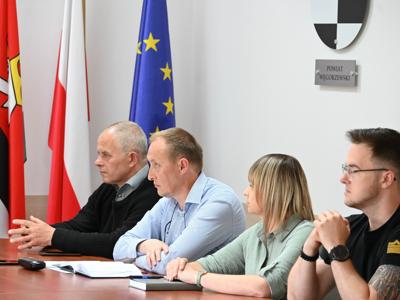 członkowie zespółów siedzą przy stole w sali konferencyjnej - trwają obrady