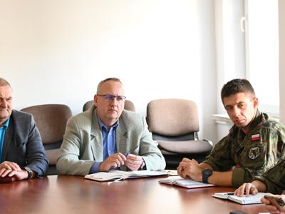 członkowie zespółów siedzą przy stole w sali konferencyjnej - trwają obrady