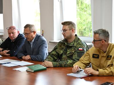członkowie zespółów siedzą przy stole w sali konferencyjnej - trwają obrady