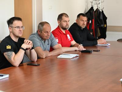 członkowie zespółów siedzą przy stole w sali konferencyjnej - trwają obrady