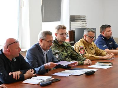 członkowie zespółów siedzą przy stole w sali konferencyjnej - trwają obrady