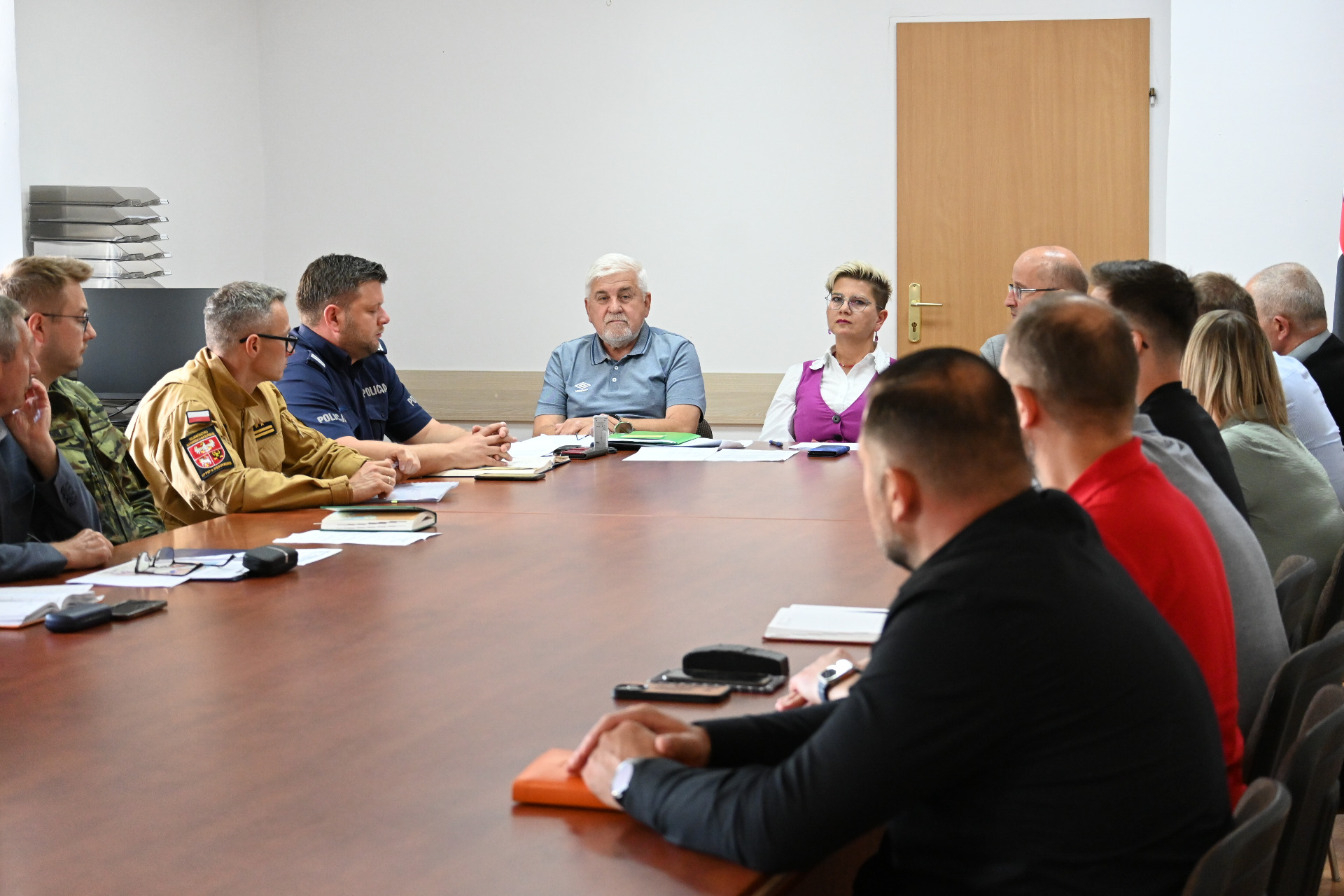 członkowie zespółów siedzą przy stole w sali konferencyjnej - trwają obrady