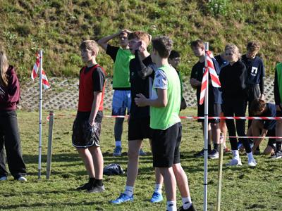 Grupa uczestników obserwująca konkurencję sportową.