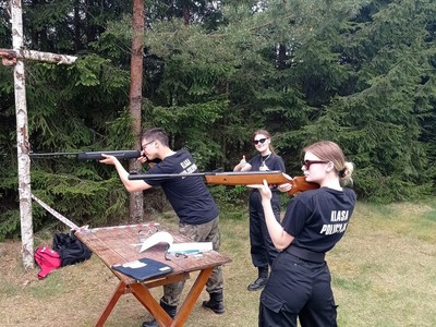 Uczestnicy w pozycjach gotowych do wykonania strzału.