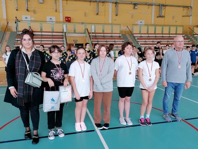 Zdjęcie grupowe drużyny dziewcząt po wręczeniu nagród. Po lewej stornie przedstawiciel Starostwa, a po prawej nauczyciel wf Pan Maciej Westfalewicz.
