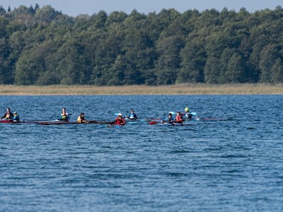 zawodnicy płyną kajakami na wodzie