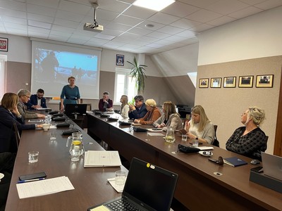 uczestnicy spotkania prowadzą dyskusję przy stole w sali konferencyjnej