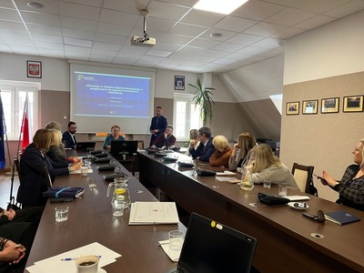 uczestnicy spotkania prowadzą dyskusję przy stole w sali konferencyjnej